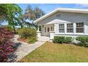 Charming front entrance with decorative door, white pillars, and well-maintained landscaping, creating curb appeal at 1390 S 1St Ave, Bartow, FL 33830