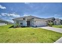 Charming single-story home with a well-manicured lawn and a concrete driveway at 1541 Leamington Ln, Winter Haven, FL 33884