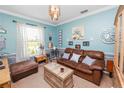 Comfortable living room with soft blue walls, natural light, and cozy leather sofa at 181 James Cir, Lake Alfred, FL 33850