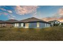 View of the home's exterior with a well-maintained lawn, and an expansive backyard at 2983 Flying Blackbird Rd, Bartow, FL 33830