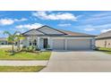 Charming single-story home featuring a well-manicured lawn, two-car garage, and neutral gray color scheme at 2983 Flying Blackbird Rd, Bartow, FL 33830