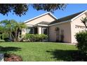 A single-story home with green grass, a brick driveway, a two car garage and mature landscaping at 3817 Osprey Pointe Cir, Winter Haven, FL 33884