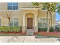 Charming front entrance with a wooden door, elegant columns, and manicured landscaping at 517 Sandstone St, Lakeland, FL 33809