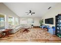 Inviting living room with a large sectional sofa, media center, and a ceiling fan at 5543 Arlington River Dr, Lakeland, FL 33811