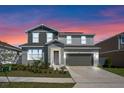 Charming two-story home with a well-manicured lawn and two car garage at 823 Folklore Ln, Haines City, FL 33844