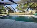 Sparkling pool within a screened enclosure, offering a private backyard view and outdoor relaxation space at 871 Thornburg Rd, Babson Park, FL 33827