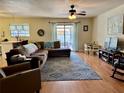 Open-concept living room with laminate floors, sliding glass doors to the lanai and a comfy sectional sofa at 996 Willowbrook Ct, Winter Haven, FL 33884