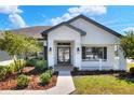 Close-up of the front porch with stylish entryway, dark trim and fresh landscaping at 140 Heritage Park Ln, Mulberry, FL 33860