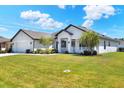 Inviting single-story home with lush landscaping, a well-maintained lawn, and attached two car garage at 140 Heritage Park Ln, Mulberry, FL 33860