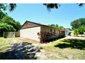 Side view of a well-maintained home with partial fencing and mature trees at 1618 Crystalview Trl, Lakeland, FL 33801