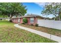 Brick home showcasing a walkway, manicured lawn, and privacy fence at 202 Saint Lucie Rd, Winter Haven, FL 33884