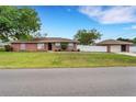 Charming single-story brick home featuring lush lawn and a detached two-car garage with ample parking at 202 Saint Lucie Rd, Winter Haven, FL 33884