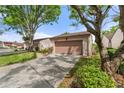 View of a single-story home showcasing a well-maintained lawn, mature trees, and an attached garage at 3545 Harbor Nw Cir, Winter Haven, FL 33881