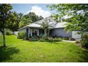 Beautiful single story home with a lush front yard featuring a metal roof and painted in a neutral color at 811 W Heron Pl, Winter Haven, FL 33884