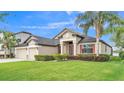 Charming home with a well-maintained lawn, mature landscaping, and a three-car garage at 1342 Heritage Landings Dr, Lakeland, FL 33805