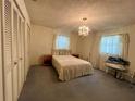Cozy bedroom featuring a comfortable bed, chandelier, and ample closet space at 1528 Hallam S Ct, Lakeland, FL 33813