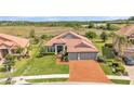 Beautiful single-story home featuring a red tile roof, brick driveway, mature landscaping, and a spacious lawn at 1983 Via Lago Dr, Lakeland, FL 33810
