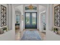 Elegant foyer featuring high ceilings, beautiful decorative doors, transom windows and tile flooring at 1983 Via Lago Dr, Lakeland, FL 33810