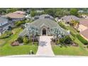 An aerial view showing the home's green roof, mature landscaping, and brick driveway at 715 Hanover Ct, Lakeland, FL 33813