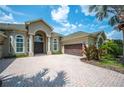 Charming front exterior with a brick driveway, a two-car garage, and mature landscaping at 715 Hanover Ct, Lakeland, FL 33813