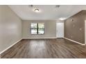 Spacious living room featuring new dark vinyl floors, neutral paint, and a bright window at 1010 Penguin Pl, Lakeland, FL 33809