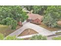 An all brick home with a long driveway and mature trees on a well manicured lawn at 1205 Scottsland Dr, Lakeland, FL 33813