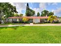 Expansive one-story home featuring a lush green lawn and mature landscaping, with a brick driveway at 1407 Easton Dr, Lakeland, FL 33803