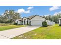Charming single-story home featuring a long driveway and attached two-car garage at 185 Heritage Park Ln, Mulberry, FL 33860
