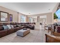 Spacious living room with tile floors, large leather sectional, and view to the dining area, perfect for entertaining at 1925 Binnacle St, Kissimmee, FL 34744