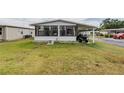 Bright house featuring a large yard, screened porch, and a convenient golf cart garage at 2055 S Floral Ave # 269, Bartow, FL 33830