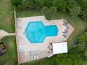 Aerial view of a community pool with lounge chairs and well maintained landscaping surrounding it at 2055 S Floral Ave # 269, Bartow, FL 33830