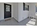 View of a covered front porch with tiled flooring, a black front door, and white siding at 2085 Long Boat Dr, Lakeland, FL 33810