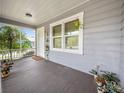 Picturesque porch view featuring neutral siding, bright white trim, and decorative plants at 219 Ariana St # A-B, Lakeland, FL 33803