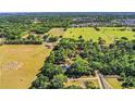 Sprawling property with a home, mature trees and large grassy field, captured in an aerial shot at 2319 D R Bryant Rd, Lakeland, FL 33810