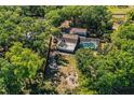 Aerial view of a home with a large yard, pool, workshop and fire pit, surrounded by mature trees at 2319 D R Bryant Rd, Lakeland, FL 33810