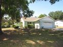Single-story home with a two-car garage, well-kept landscaping, and mature trees at 281 Glenridge S Loop, Lakeland, FL 33809