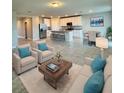 Open-concept living room showcasing kitchen island, modern decor, and dining area in a spacious setting at 3208 Weitzel Dr, Haines City, FL 33844