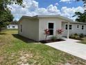 Side view of a newly painted home with green lawn, landscaping, new driveway and walkways at 3227 Decatur Ave, Lakeland, FL 33805