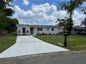 Attractive one-story home with a new driveway, grassy lawn and manicured landscaping around the house at 3227 Decatur Ave, Lakeland, FL 33805