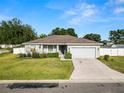 Well-maintained one-story home featuring a manicured front yard, charming porch, and an attached two-car garage at 3425 Sutton Ridge St, Lakeland, FL 33810