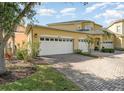 Charming yellow home with a three-car garage and brick-paved driveway at 3923 Serenade Ln # 426, Lakeland, FL 33811
