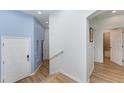 Bright foyer with wood floors, and blue accent wall leading to bathroom at 3923 Serenade Ln # 426, Lakeland, FL 33811