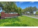 Gated community entrance with brick signage and lush landscaping at 405 Enclave Pl # 405, Lakeland, FL 33803