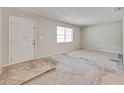 Spacious living room with a front door, a window, and flooring in need of replacing at 407 Ne 8Th St, Mulberry, FL 33860