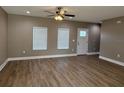 Open living room with wood-look flooring, a ceiling fan and two windows providing natural light at 4189 Radford Rd, Bartow, FL 33830