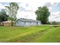 Single-story home with a well-kept lawn and a simple, inviting design on a sunny day at 4215 Sunnyside Dr, Lakeland, FL 33810