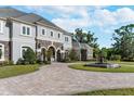 Beautiful home featuring a circular driveway, fountain, manicured lawn, and stone accents at 460 Canterwood Dr, Mulberry, FL 33860