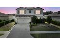 Charming two-story home with well-maintained landscaping, and an attached two-car garage at twilight at 4886 St James Ln, Winter Haven, FL 33881