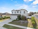 Charming two-story home with a well-manicured lawn, solar panels, and an attached garage at 4886 St James Ln, Winter Haven, FL 33881