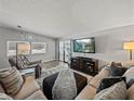 Comfortable living room featuring a plush sectional sofa, large television, and wood-look flooring at 5016 Forest Crest Dr, Lakeland, FL 33810